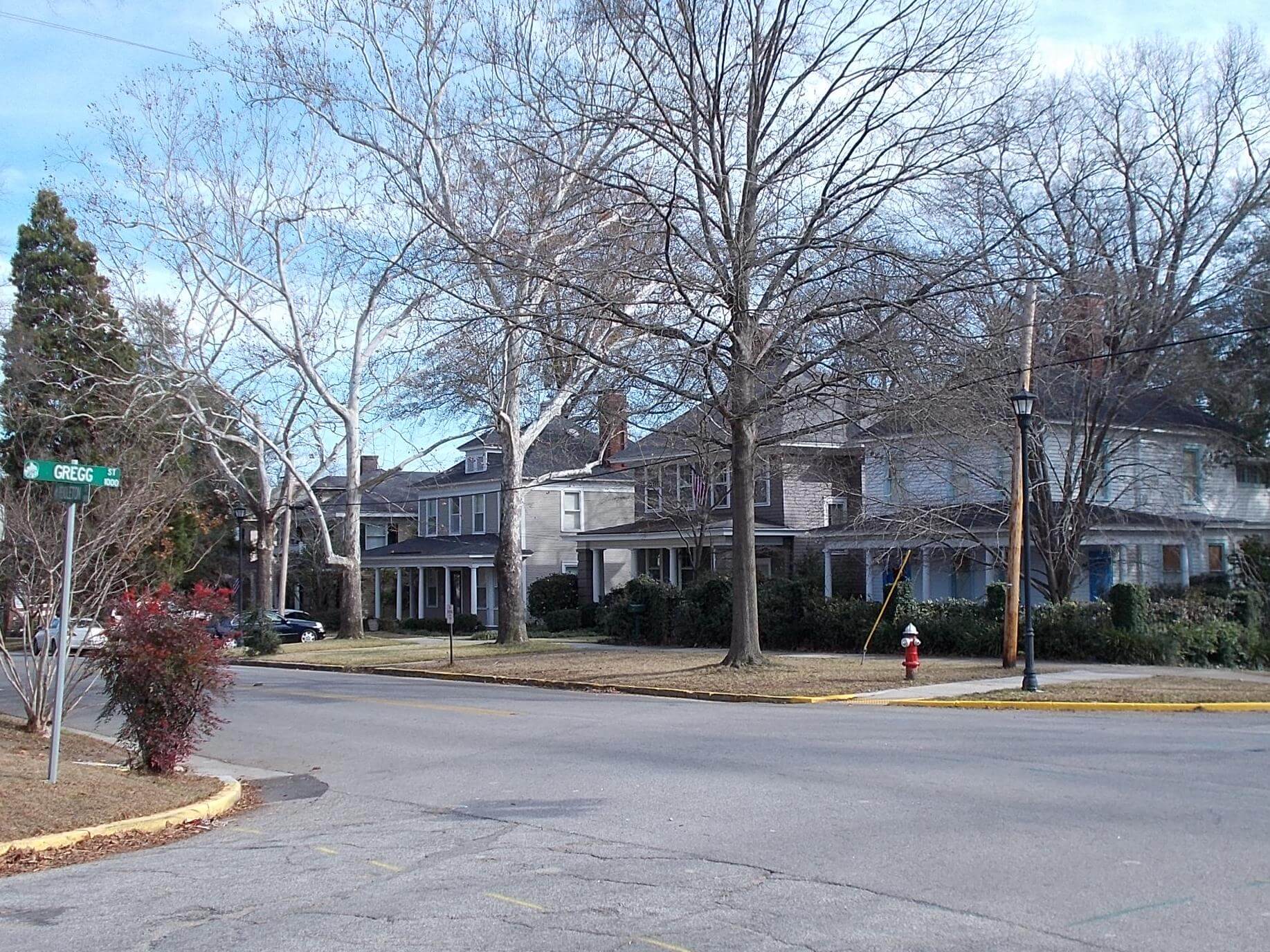 Photograph of a street corner with two story homes with porches