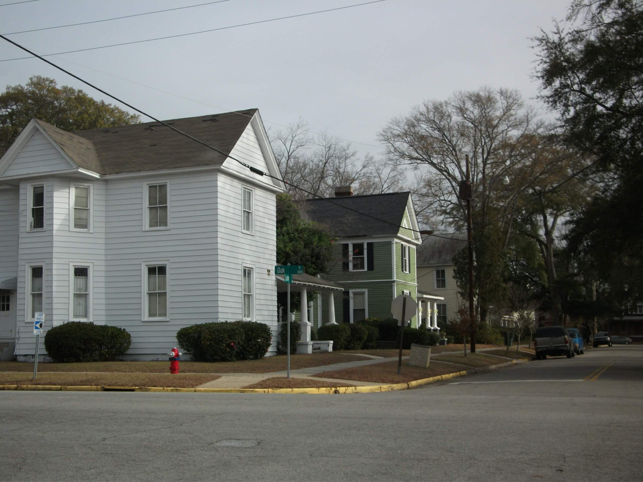 Photograph of a street corner with two-story wood-sided homes
