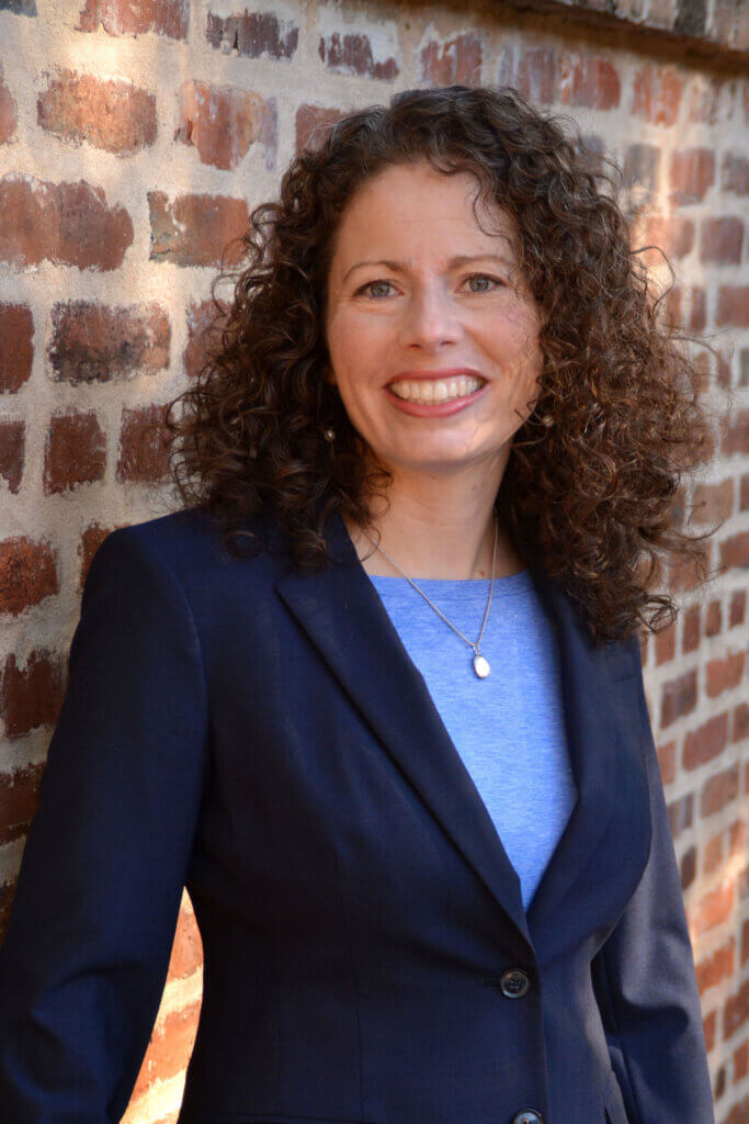 Photo of Leigh DeForth against a brick wall