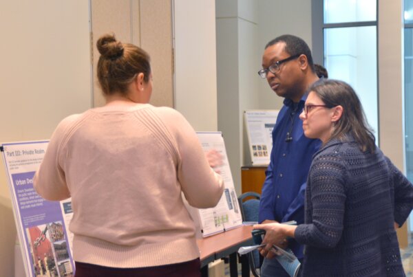 city staff speaks with members of the public in front of the boards discussing how the proposed downtown guidelines will address the private realm